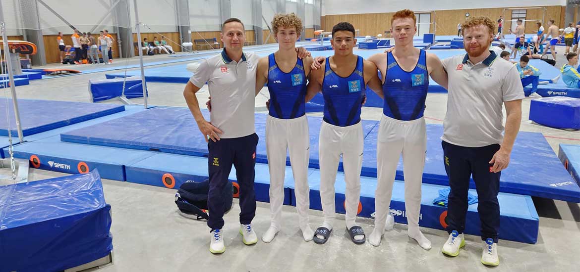 Tre gymnaster i mitten och två ledare på varje sida. 