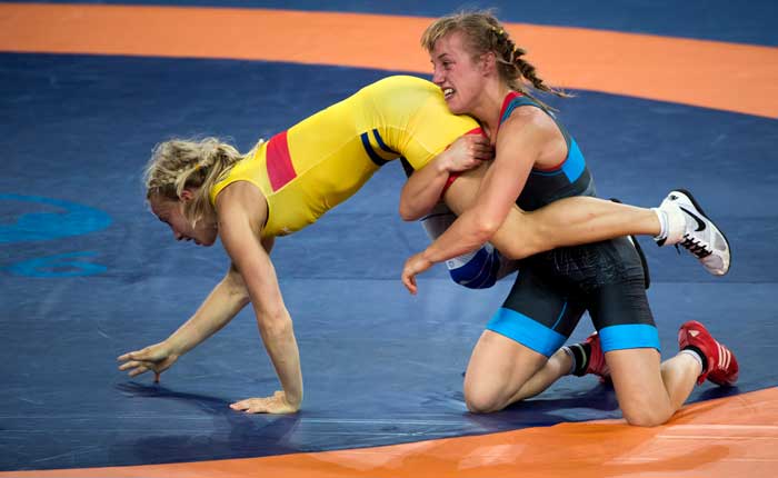 Två kvinnliga brottare i en brottningsmatch där den ene har ett tag om benen på sin motståndare.