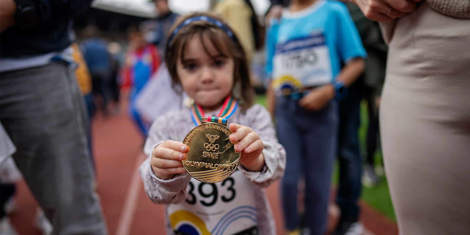 Flicka visar upp medalj